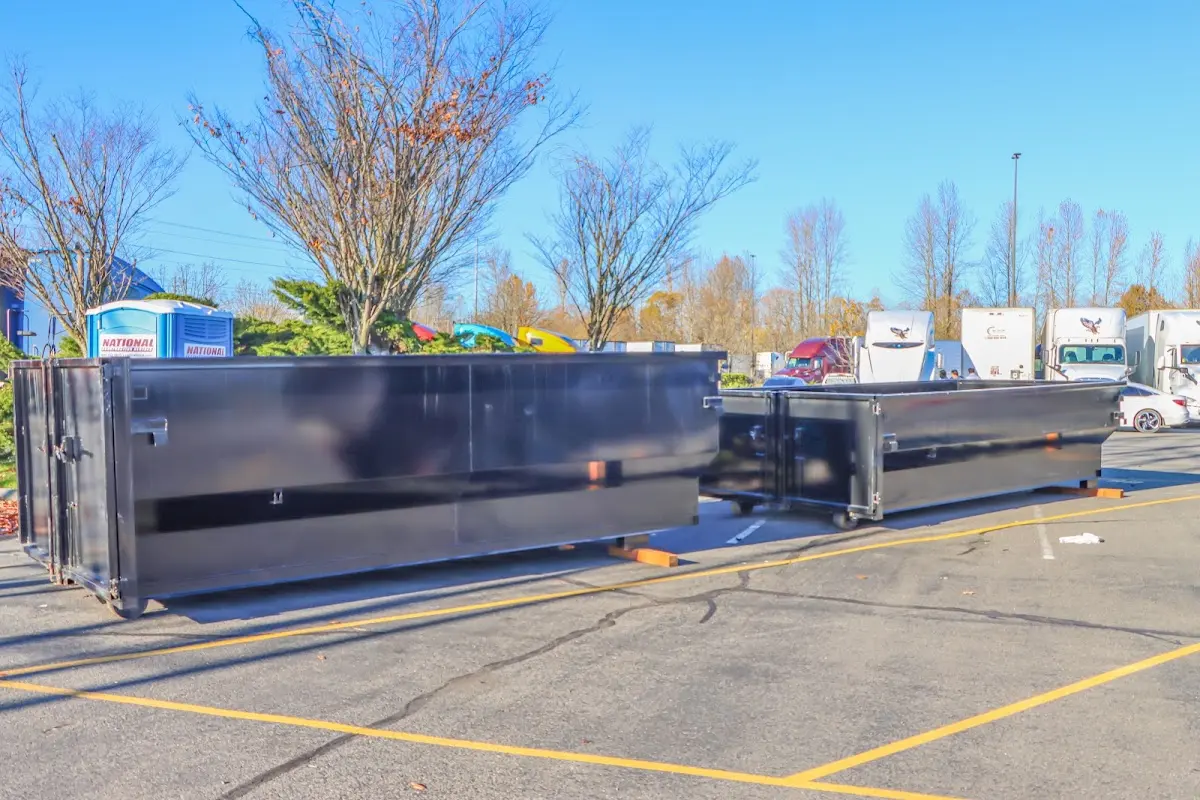 Professional dumpster rental service with roll-off container on residential driveway in East Rochester